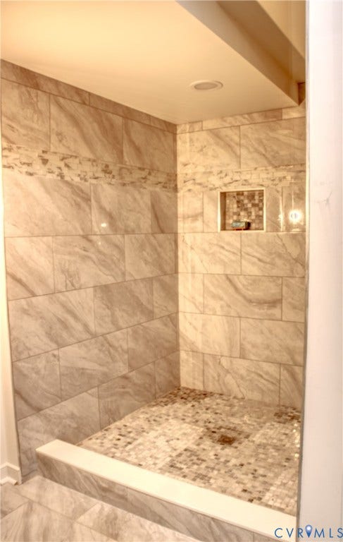 5004 Fairlake Lane, Henrico, VA 23060 Walk-in shower featuring large format wall tiling, a decorative mosaic accent band, and a mosaic tile shower floor