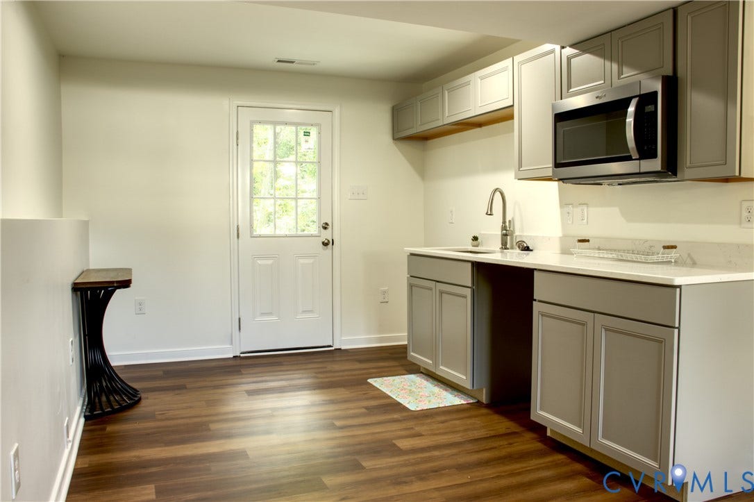 5004 Fairlake Lane, Henrico, VA 23060 Kitchenette featuring wood-finish flooring, light gray cabinetry, white countertops, and a stainless steel microwave