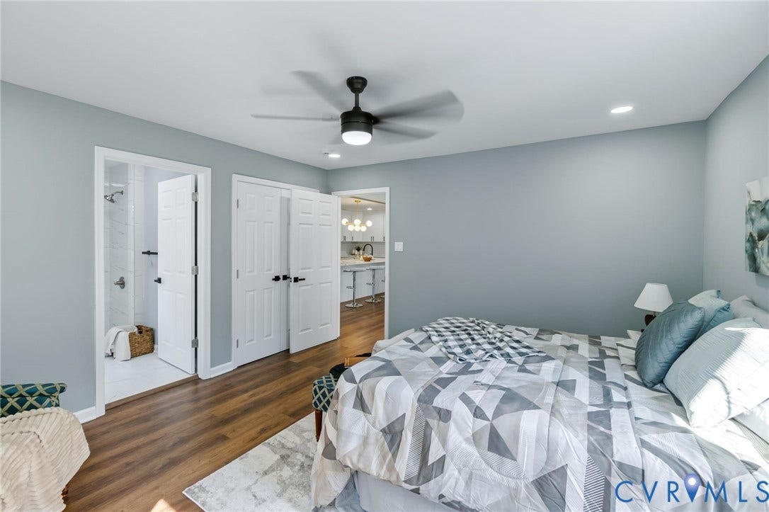 Wood-finish flooring with a modern ceiling fan, recessed lighting, and a walk-in shower with white tile