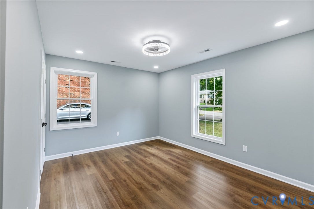 Wood-finish flooring, white trim, recessed lighting, and a modern ceiling light fixture