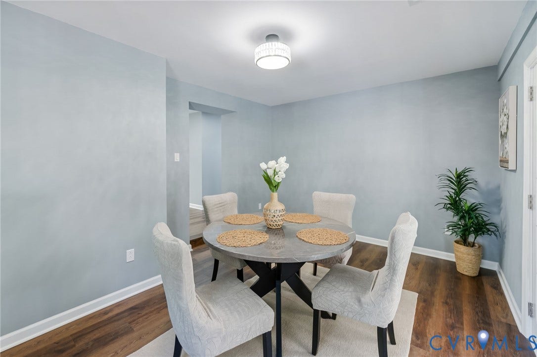 Recessed ceiling lighting, wood-finish flooring, light blue wall paint, white trim, and a decorative ceiling light fixture