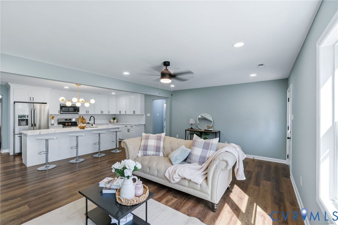 Open-concept living area with wood-finish flooring, recessed lighting, and a ceiling fan