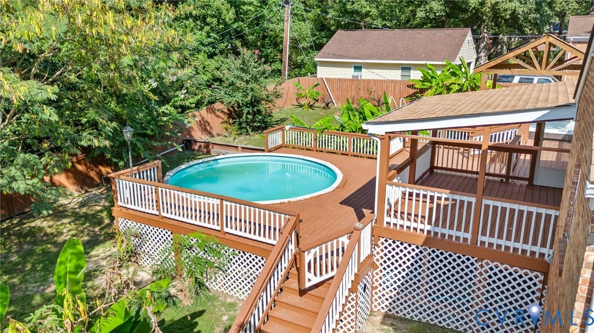 Multi-level deck with a built-in swimming pool and white lattice skirting
