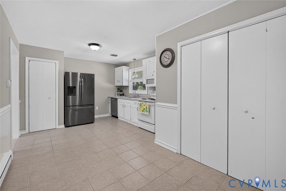 6302 Phobus Court, Richmond, VA 23234 Kitchen featuring white cabinetry, tile flooring, stainless steel refrigerator, white appliances, and ample storage with multiple bi-fold doors