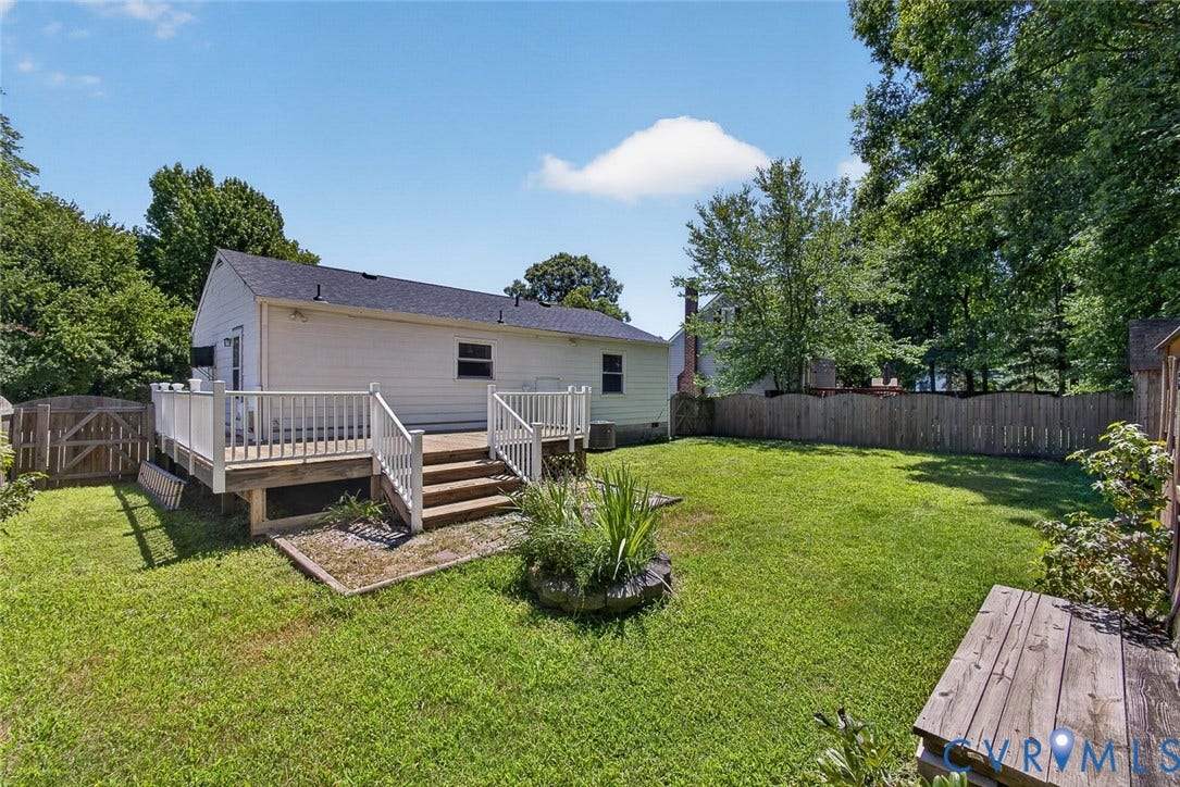 6302 Phobus Court, Richmond, VA 23234 Spacious rear yard featuring a large wood deck with steps, a full privacy fence, and mature perimeter trees