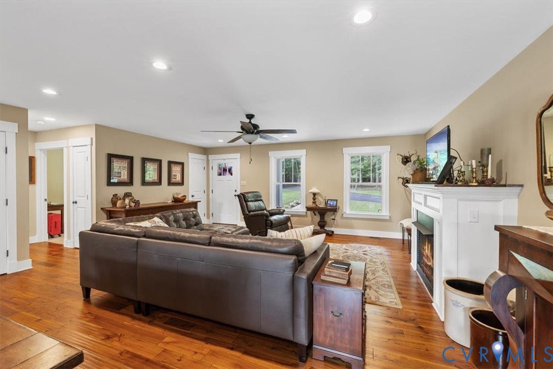 Spacious living area featuring wood-finish flooring, recessed lighting, and a ceiling fan