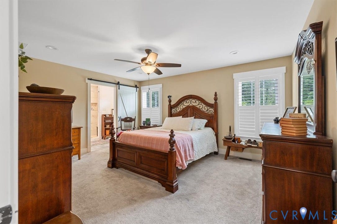 Neutral wall tones complement the light-colored carpeted flooring in this bedroom space