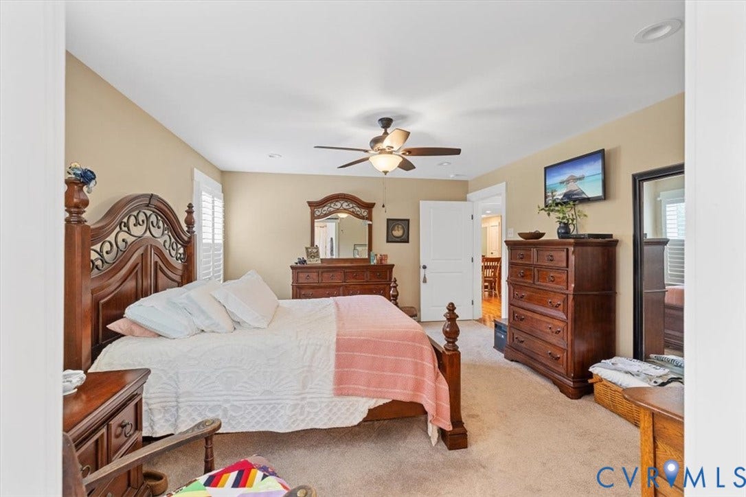 Carpeted room featuring a ceiling fan with integrated lighting, recessed lighting, and a white paneled door