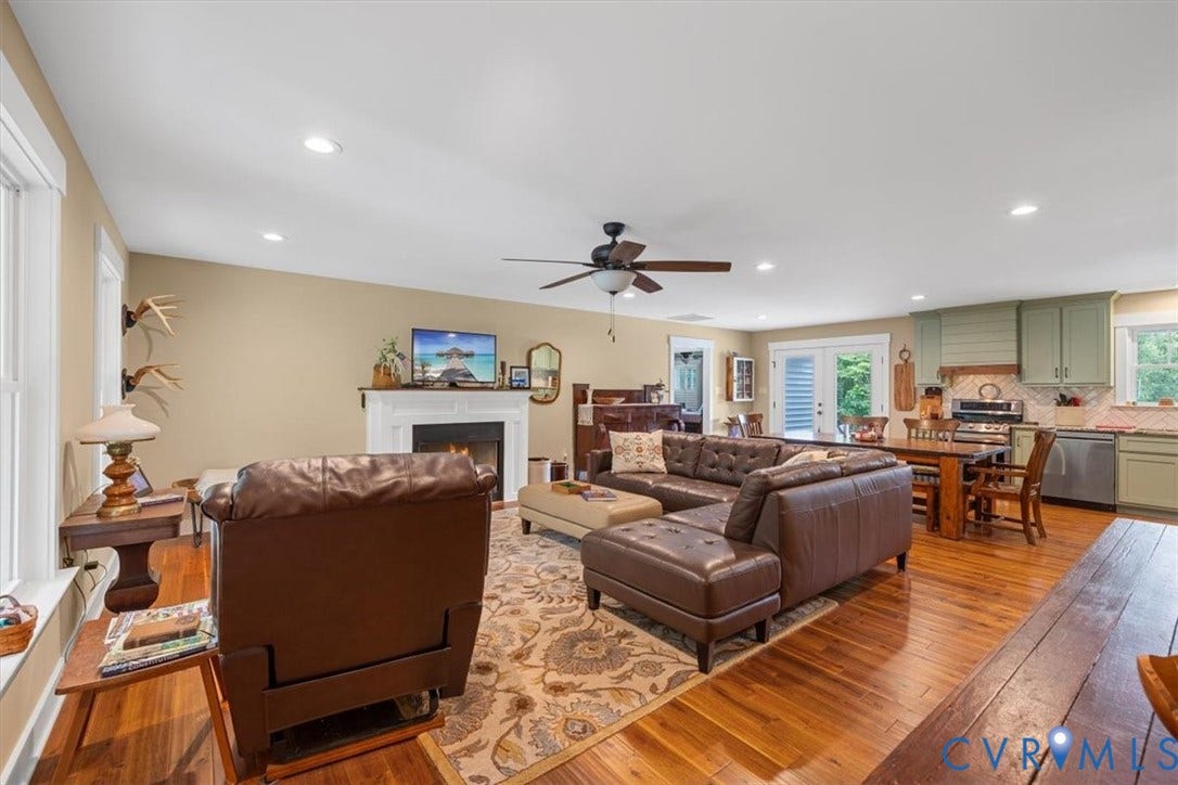 Open-concept living area featuring wood-finish flooring, recessed lighting, and a ceiling fan