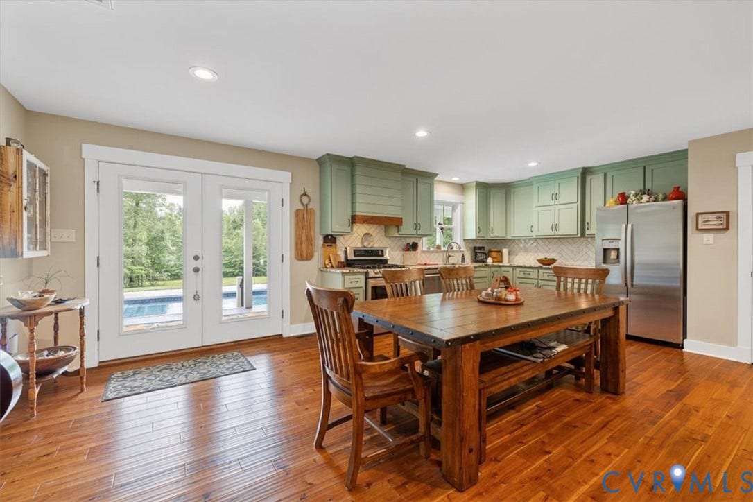 Kitchen and dining area featuring wood-finish flooring, recessed lighting, and white French doors opening to an exterior swimming pool