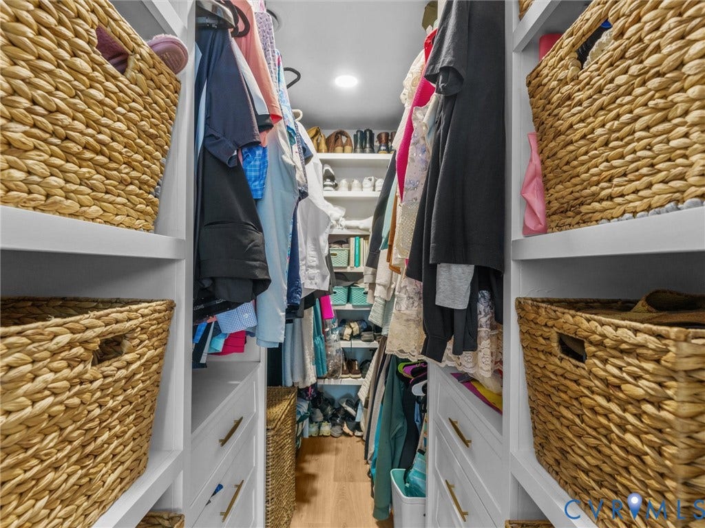 8216 Indian Springs Road, Richmond, VA 23237 Custom closet system featuring white shelving, integrated drawers with gold-tone hardware, and abundant hanging space