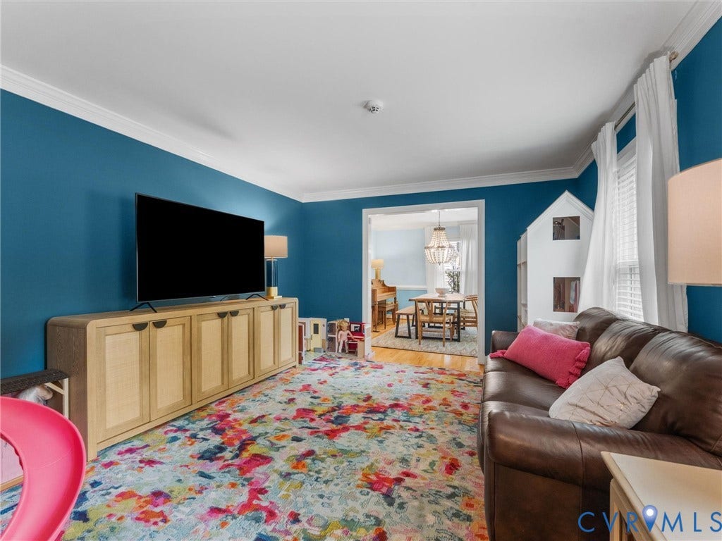 8216 Indian Springs Road, Richmond, VA 23237 Spacious room featuring bold wall color, crown molding, and a wide cased opening to an additional room