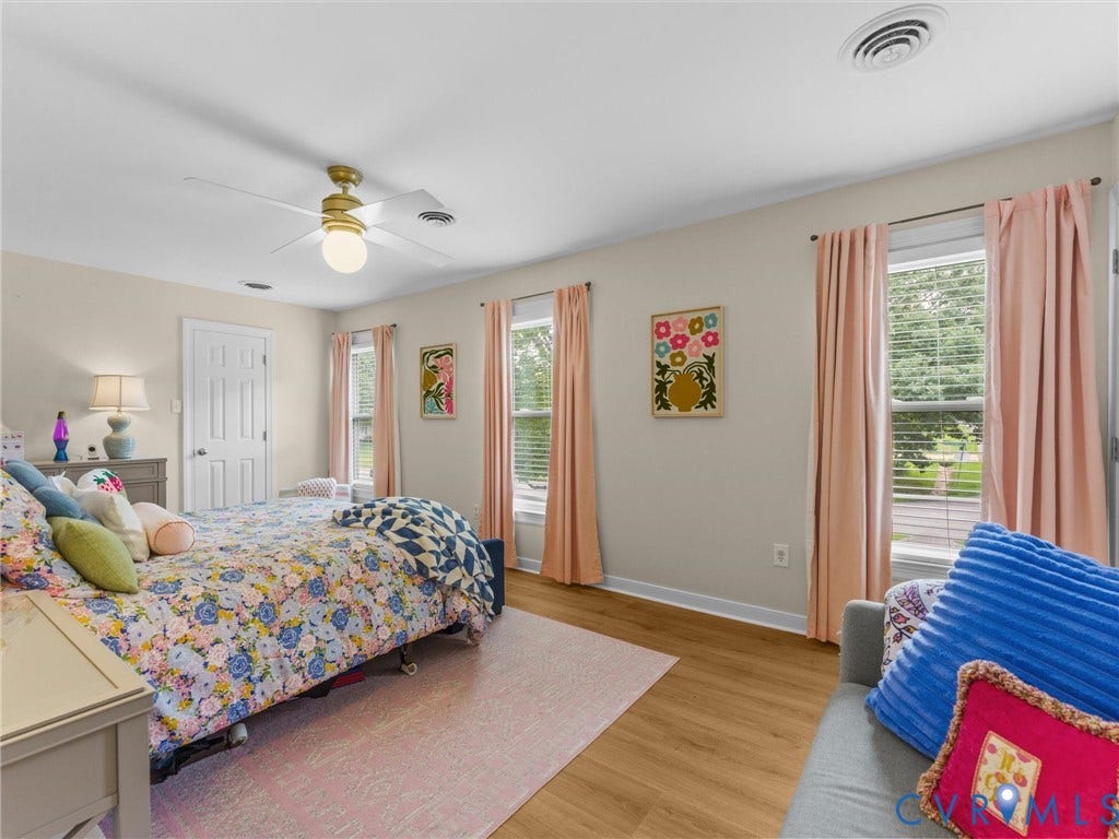 8216 Indian Springs Road, Richmond, VA 23237 Spacious room featuring wood-finish flooring, a ceiling fan with integrated lighting, and multiple windows providing natural light