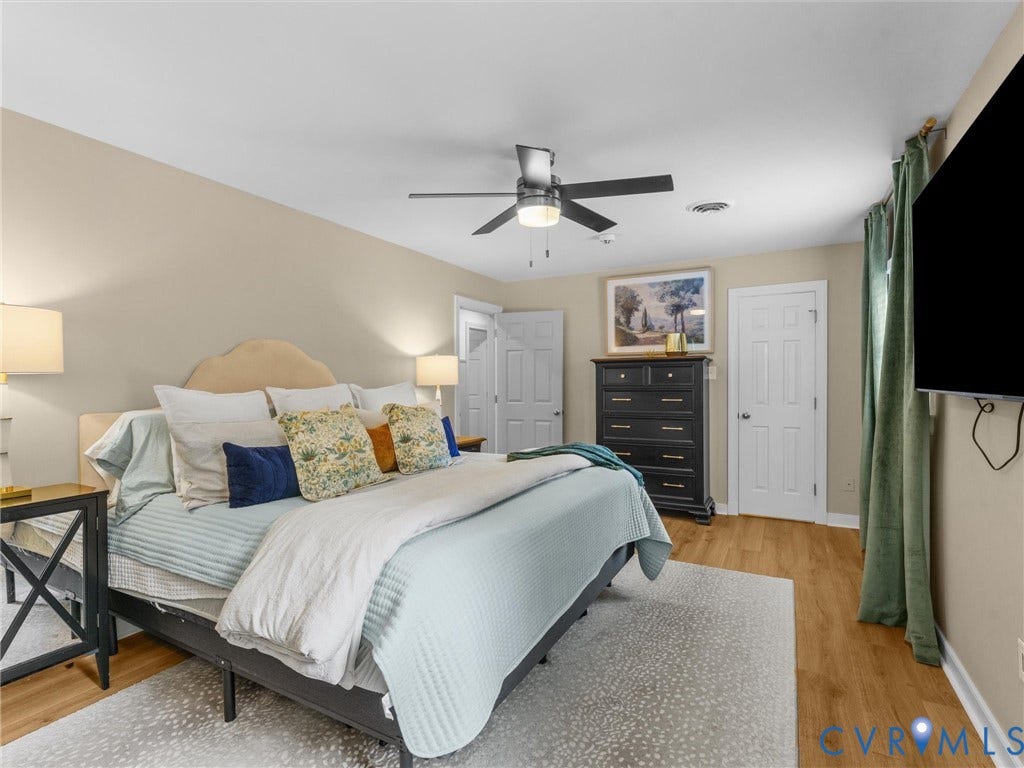 8216 Indian Springs Road, Richmond, VA 23237 Spacious bedroom featuring wood-finish flooring, a contemporary ceiling fan, and multiple white panel doors