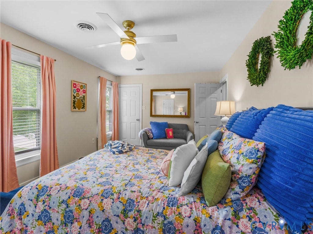 8216 Indian Springs Road, Richmond, VA 23237 Spacious interior room featuring a ceiling fan with integrated lighting, two windows with blinds and drapery, a paneled door, and neutral wall paint