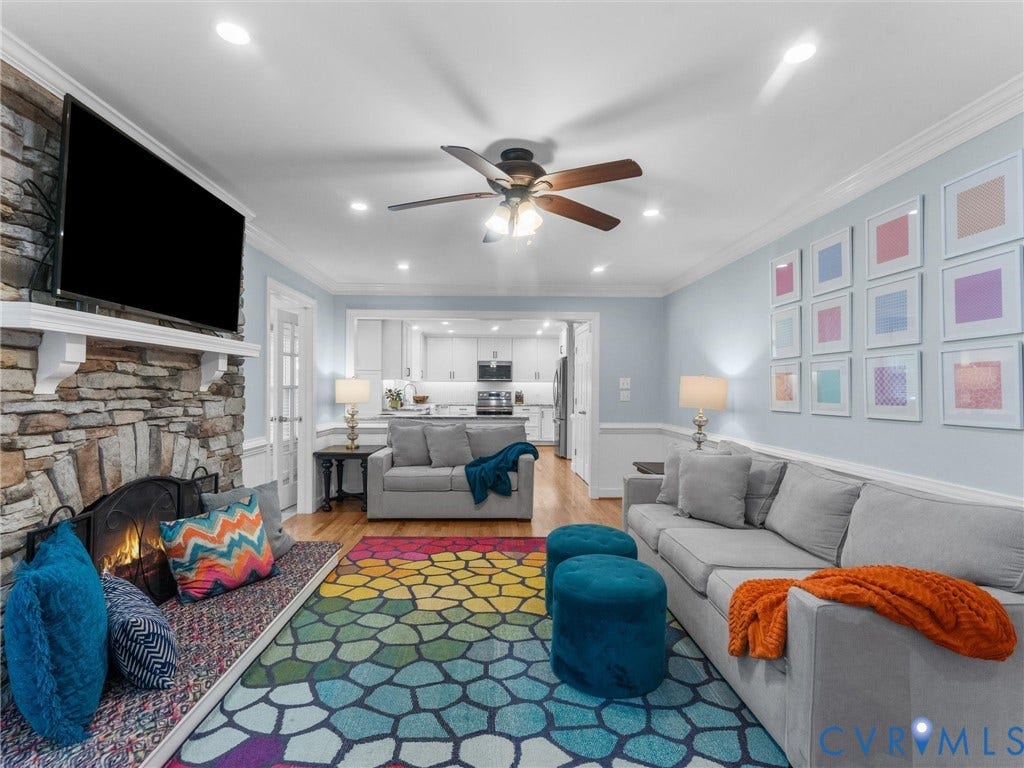 8216 Indian Springs Road, Richmond, VA 23237 Living area featuring a stone-clad fireplace with a built-in hearth seat, recessed lighting, crown molding, and wood-finish flooring