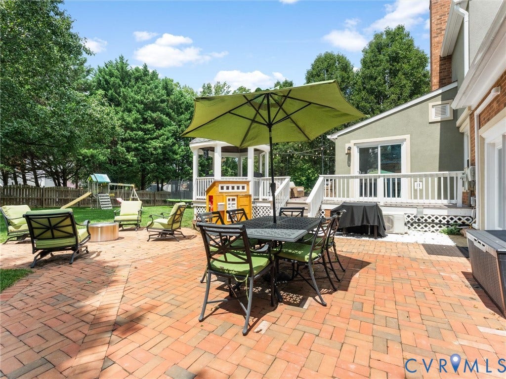 8216 Indian Springs Road, Richmond, VA 23237 Expansive brick paver patio featuring a built-in fire pit, a white wooden deck with railing, and a white gazebo