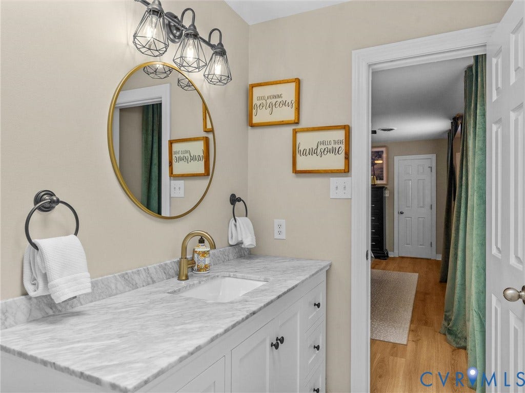 8216 Indian Springs Road, Richmond, VA 23237 Vanity featuring a white undermount sink, a light-toned countertop, and a brushed gold faucet