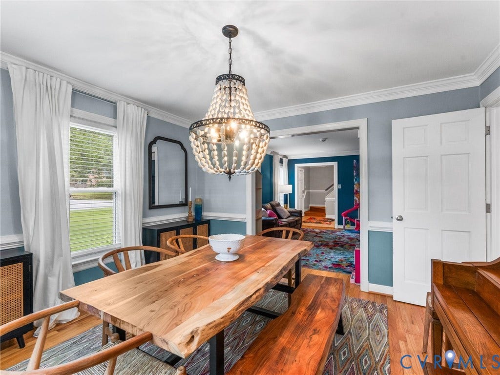 8216 Indian Springs Road, Richmond, VA 23237 Dining area featuring a prominent beaded chandelier, hardwood flooring, and white trim