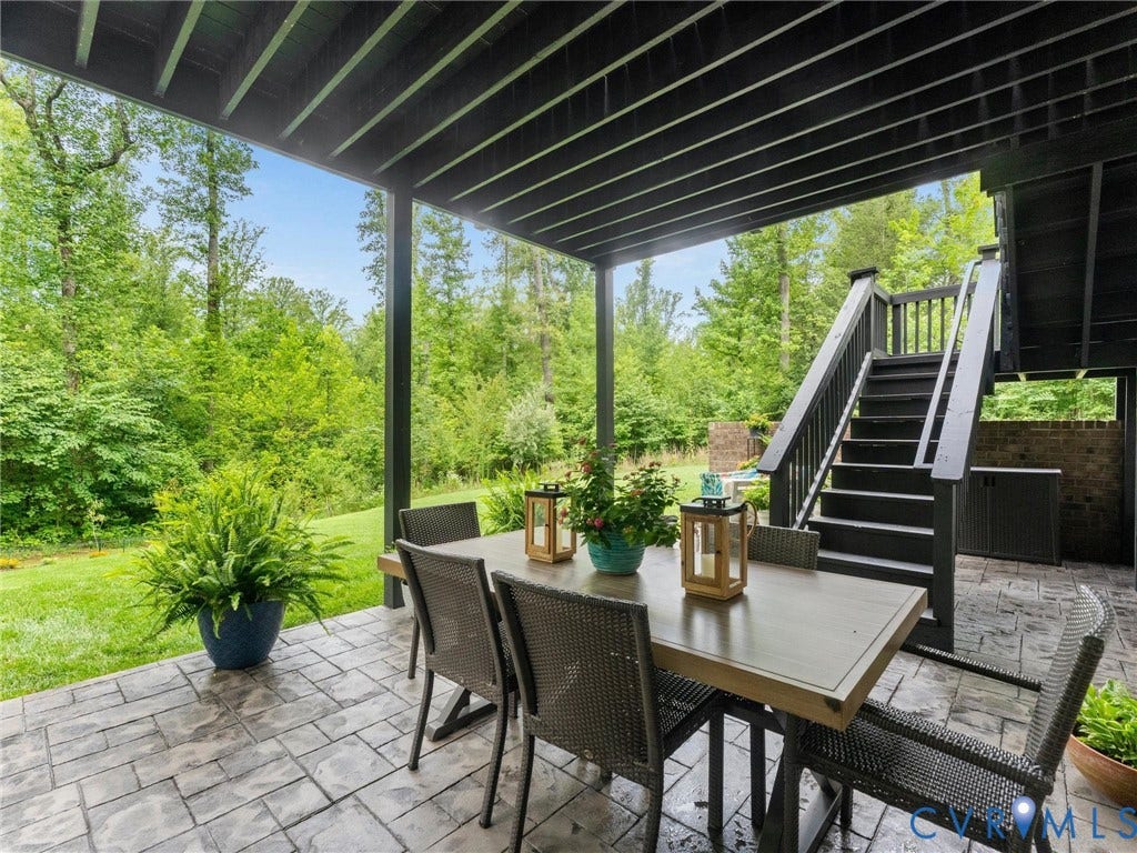 3647 Walkers Creek, Powhatan, VA 23139 Covered patio featuring stamped concrete flooring, dark-stained wood ceiling, and direct access to an exterior staircase