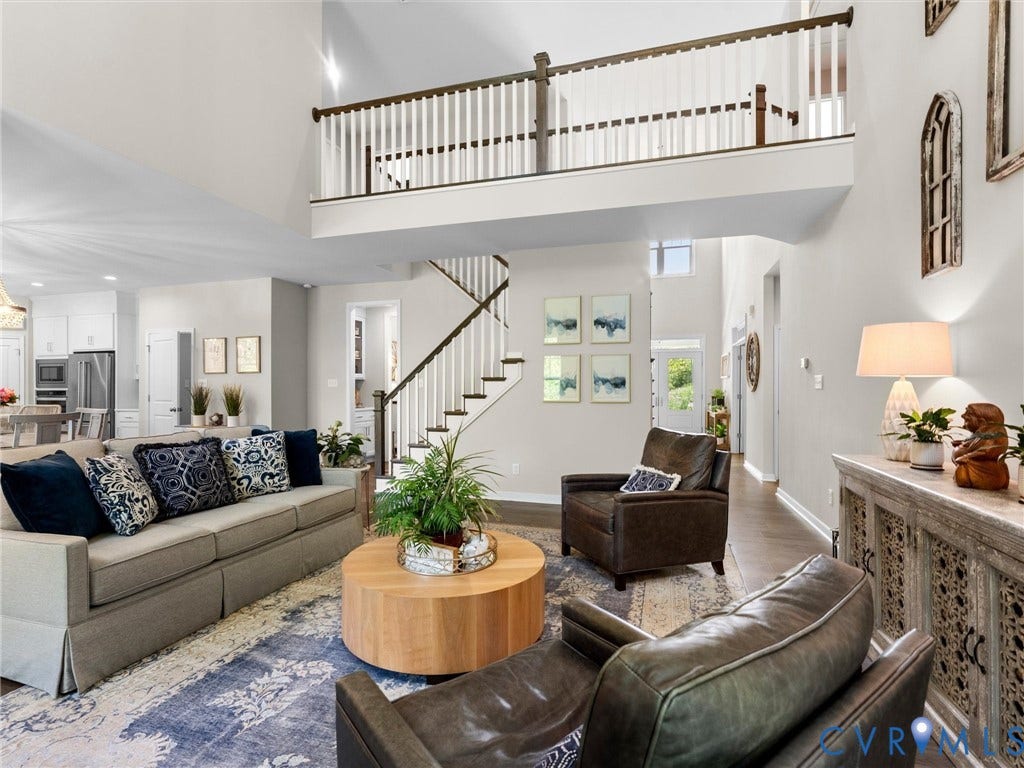 3647 Walkers Creek, Powhatan, VA 23139 Two-story ceiling, open concept layout, wood-finish flooring, white spindle staircase with dark wood handrail, and an upper-level balcony