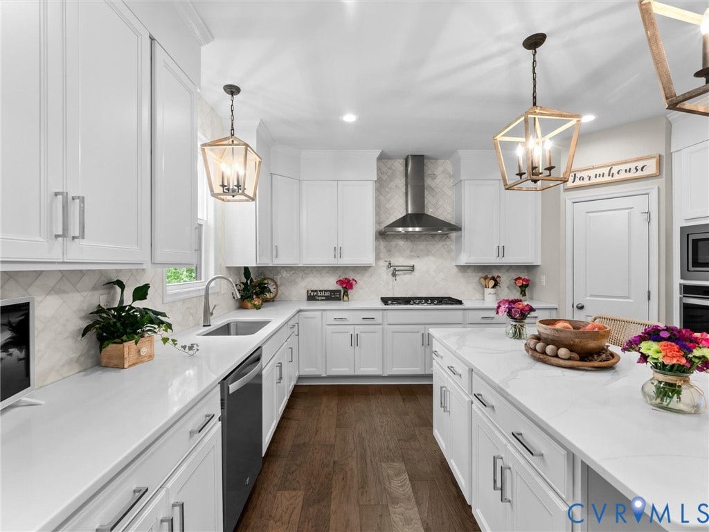 3647 Walkers Creek, Powhatan, VA 23139 White shaker-style cabinetry, wood-finish flooring, stainless steel appliances, pendulum lighting, and a kitchen island with built-in storage