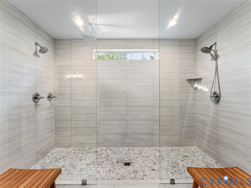 3647 Walkers Creek, Powhatan, VA 23139 Glass-enclosed shower with a rainfall showerhead, handheld shower fixture, and pebble tile flooring