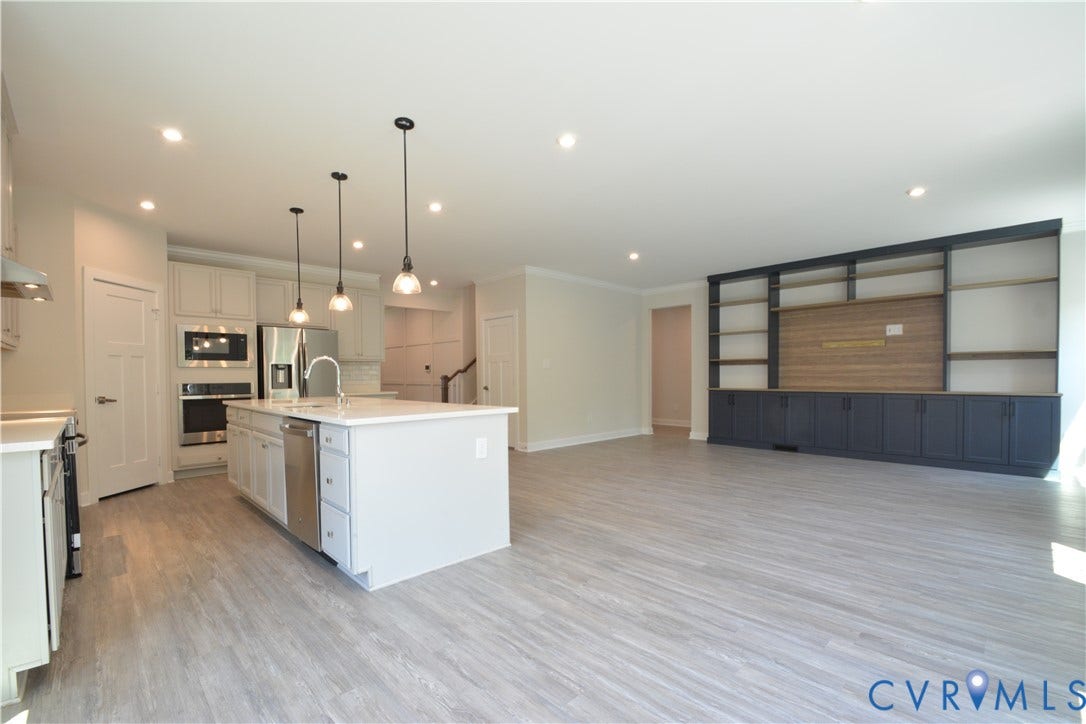9201 Brett Drive, Bayhill Pointe West, Chesterfield, VA 23112 Open-concept living space featuring LVP flooring, recessed lighting, and a built-in entertainment center with shelving and storage