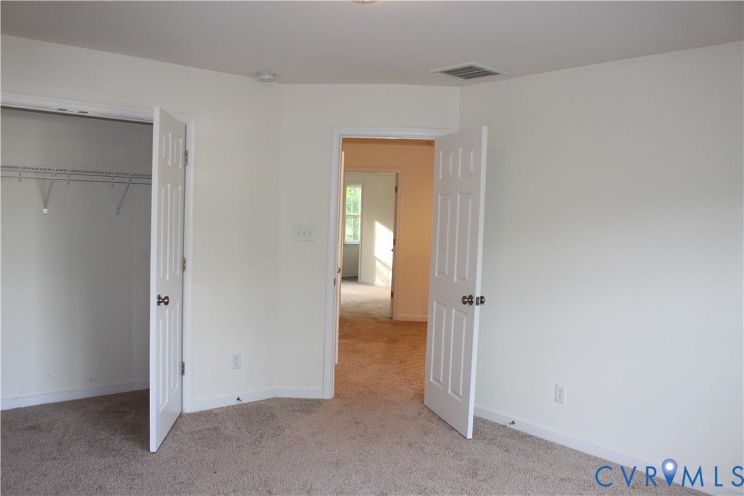 Neutral wall finishes and light-toned carpet flooring create a versatile interior
