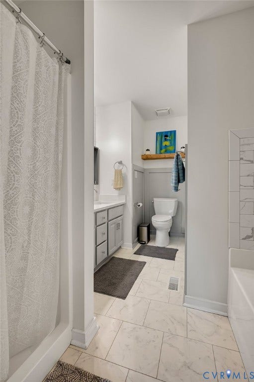 5612 Jessup Station Place, Chesterfield, VA 23234 Bathroom featuring light-toned rectangular floor tiles, a built-in bathtub with subway tile surround, a single vanity with gray cabinetry and white countertop, and wainscoting