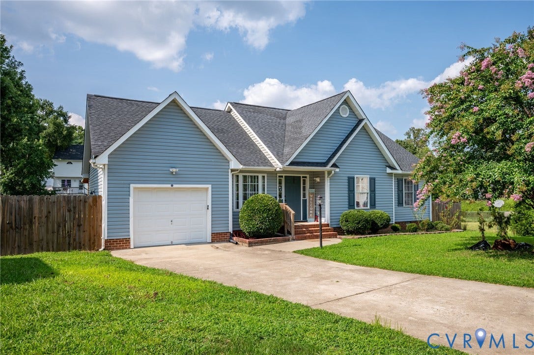 5612 Jessup Station Place, Chesterfield, VA 23234 Light blue siding exterior featuring a dark asphalt shingle roof, attached single-car garage, concrete driveway, and a front yard with mature landscaping