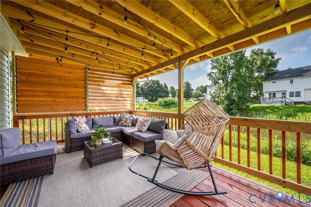 5612 Jessup Station Place, Chesterfield, VA 23234 Expansive covered deck featuring a red-stained wood-finish floor, wood railing, and plank ceiling with string lighting