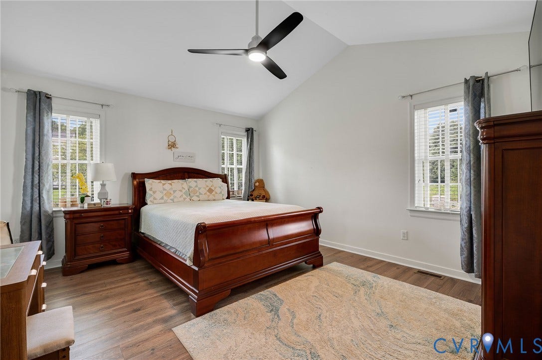 5612 Jessup Station Place, Chesterfield, VA 23234 Spacious bedroom with vaulted ceilings, two large windows, wood-finish flooring, and a modern ceiling fan