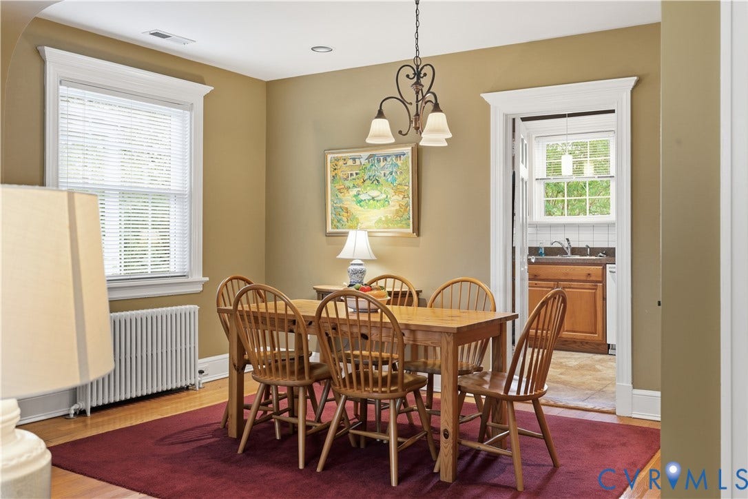 4207 W Grace Street, Sauer's Gardens, Richmond, VA 23230 Dining area featuring hardwood flooring, a window with white blinds, and a doorway with white trim