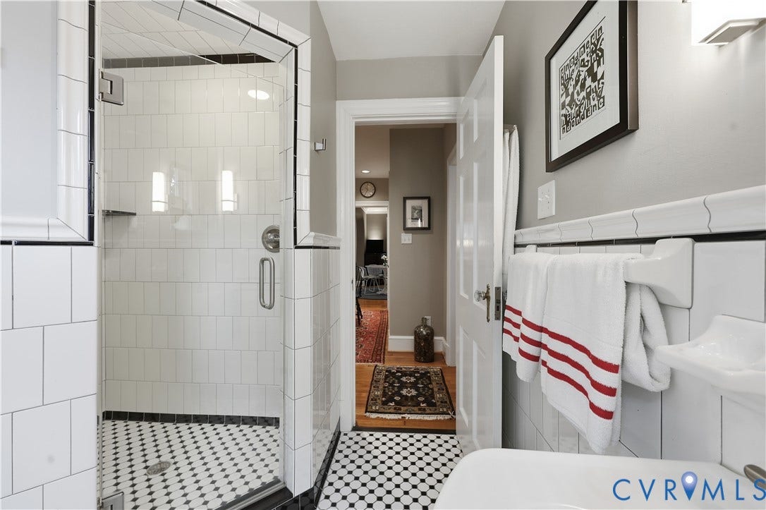 4207 W Grace Street, Sauer's Gardens, Richmond, VA 23230 Shower stall featuring clear glass enclosure, vertical subway tile, and black and white penny tile flooring