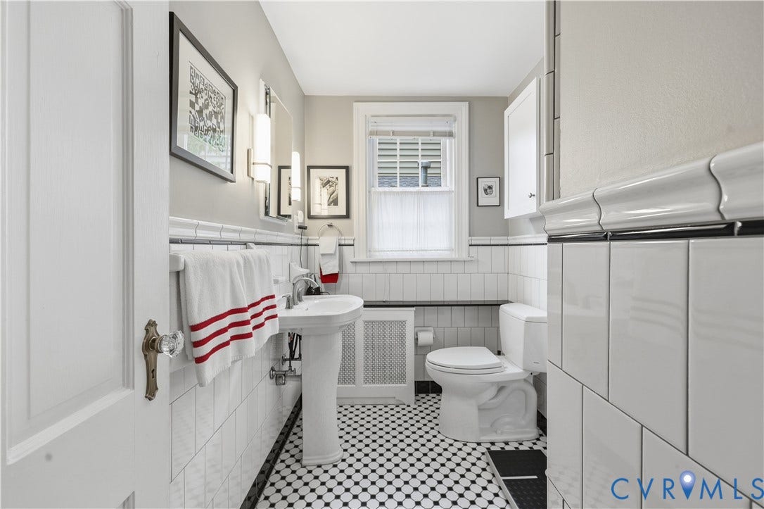 4207 W Grace Street, Sauer's Gardens, Richmond, VA 23230 Bathroom featuring black and white mosaic tile flooring, a pedestal sink, white subway tile wainscoting, a window with louvered blinds, and a built-in wall cabinet