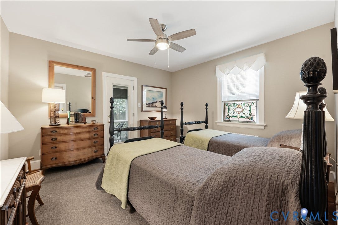 4207 W Grace Street, Sauer's Gardens, Richmond, VA 23230 Carpeted room with a ceiling fan, a window featuring a decorative stained glass panel, and an exterior door providing additional light