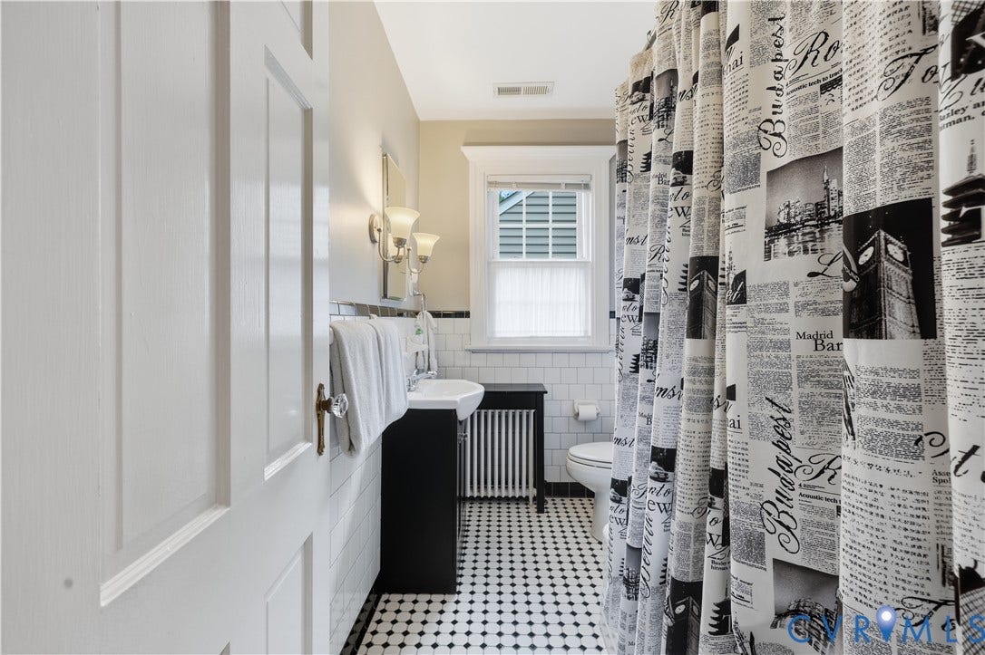 4207 W Grace Street, Sauer's Gardens, Richmond, VA 23230 Bathroom featuring white subway tile walls, black and white mosaic tile flooring, a pedestal sink with a dark wood-finish vanity, and a window with white blinds
