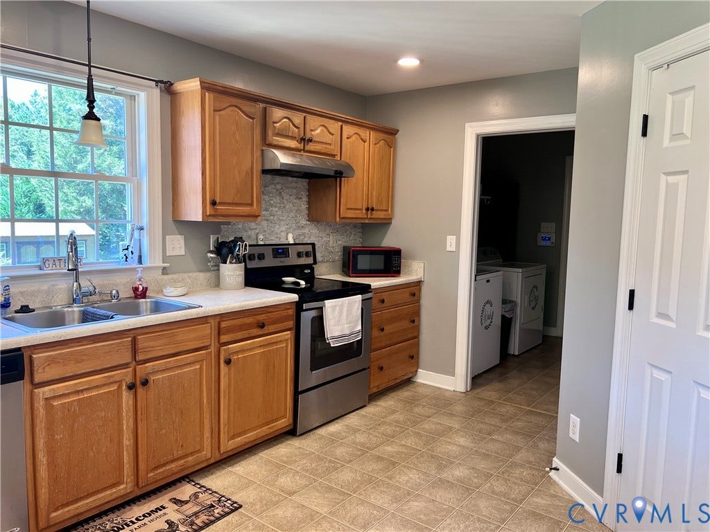 2301 Graceland Drive, Powhatan, VA 23139 Kitchen featuring wood cabinetry, stainless steel appliances, laminate countertops, and a tiled backsplash