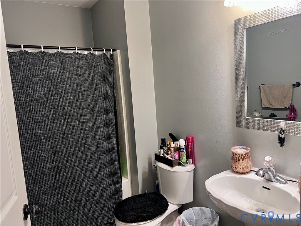 2301 Graceland Drive, Powhatan, VA 23139 Bathroom featuring a pedestal sink with a single-handle faucet, a toilet, a shower/tub combination, and a mirrored vanity with an integrated light fixture