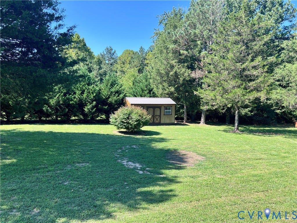 2301 Graceland Drive, Powhatan, VA 23139 Expansive green lawn with a wood-sided storage shed featuring a metal roof and a small window