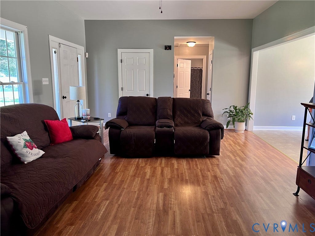 2301 Graceland Drive, Powhatan, VA 23139 Spacious living area featuring wood-finish flooring, light gray wall paint, and white trim throughout