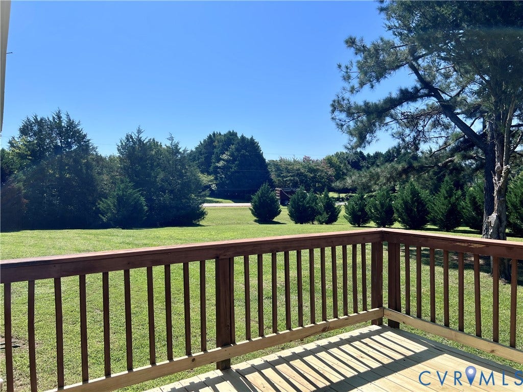 2301 Graceland Drive, Powhatan, VA 23139 Spacious outdoor deck with natural wood flooring and a stained wood railing, overlooking a manicured lawn and mature trees