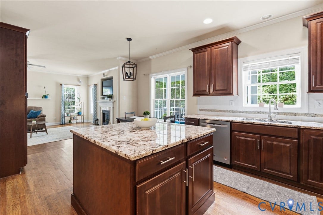 8343 Shagreen Court, The Highlands, Chesterfield, VA 23838 Kitchen island with granite countertop, dark wood-finish cabinetry, and stainless steel dishwasher