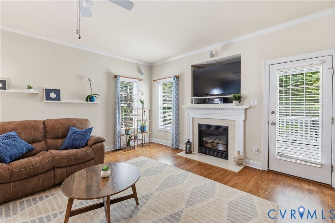 8343 Shagreen Court, The Highlands, Chesterfield, VA 23838 Hardwood flooring, crown molding, white fireplace with mantel, white ceiling fan, and multiple windows