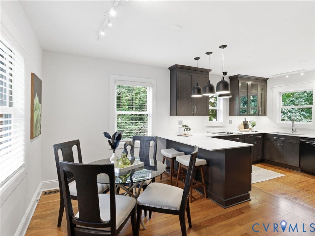 Hardwood flooring, white countertops, dark cabinetry, recessed lighting, and a kitchen island with pendant lighting