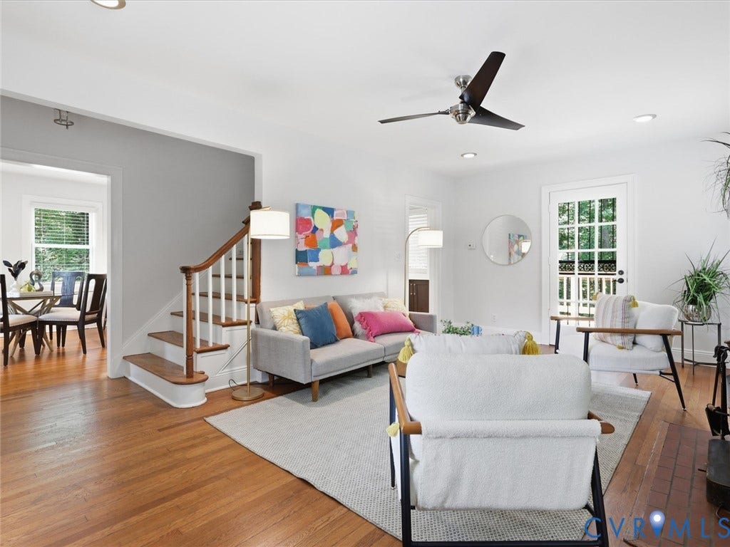 Hardwood flooring, white painted walls, recessed lighting, ceiling fan, and a wood staircase with white risers