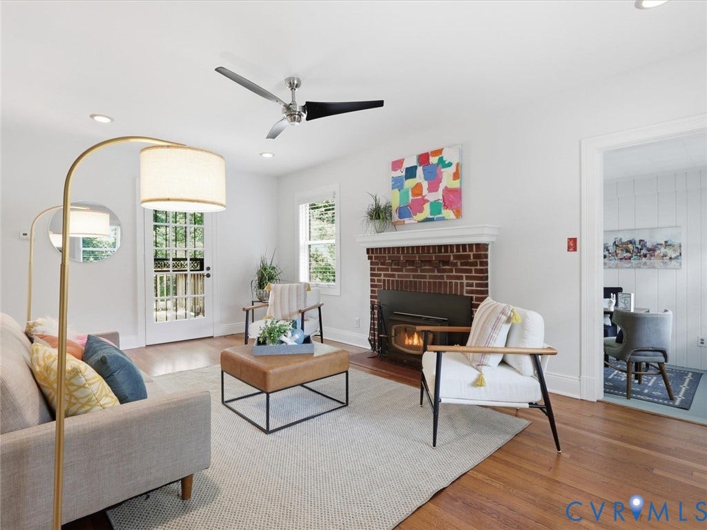 Hardwood flooring, brick fireplace with mantel, ceiling fan with light, recessed lighting, and a glass-paneled door