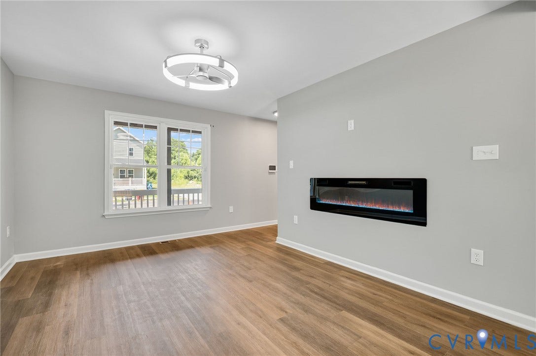 425 BYRNE Street, Petersburg, VA 23803 Living area featuring an integrated linear electric fireplace, wood-finish flooring, and a modern ceiling fan with integrated lighting