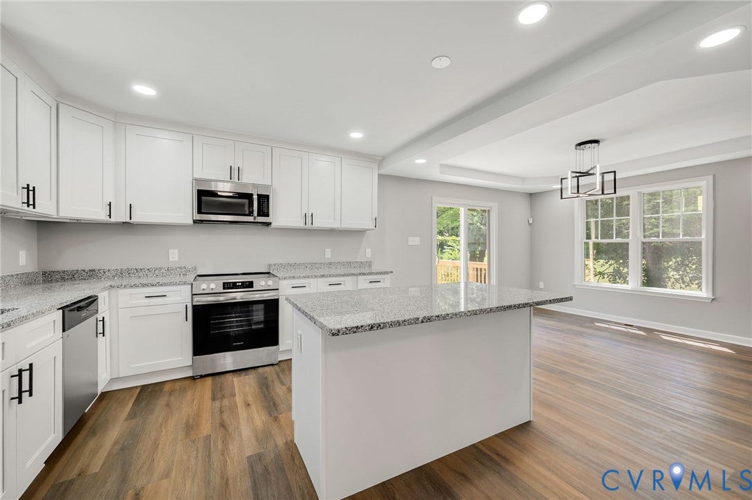 425 BYRNE Street, Petersburg, VA 23803 Modern kitchen featuring white cabinetry, granite countertops, stainless steel appliances, and wood-finish flooring